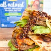 Scallion pancake breakfast wrap cut in half to show layers with a box of turkey sausages in the background.