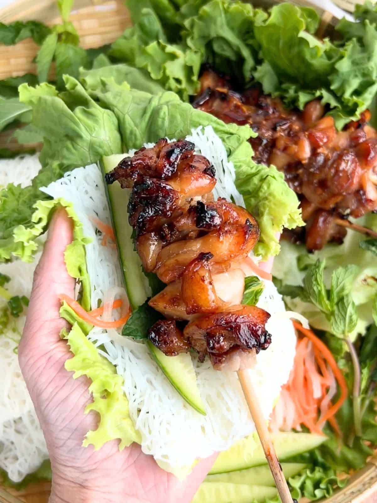 Serving the hot honey chicken with lettuce, rice noodles and vegetables in a wrap.
