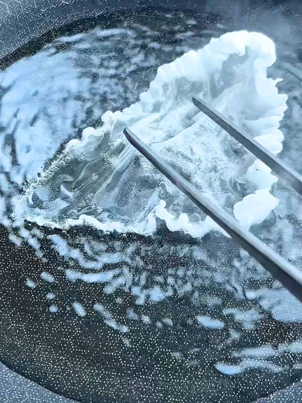 Frying rice paper until crispy in a pan with oil.