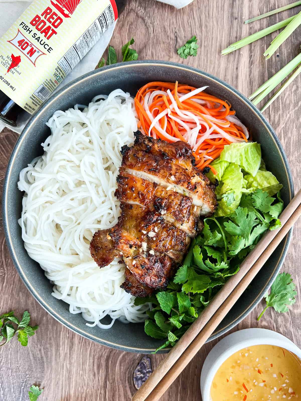 Air fryer lemongrass chicken thighs served in a bowl with fish sauce on the side.