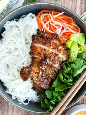 Air fryer lemongrass chicken served in a bowl with noodles and veggies.