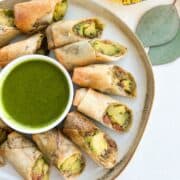 Overhead shot of avocado egg rolls served with a tamarind dipping sauce.