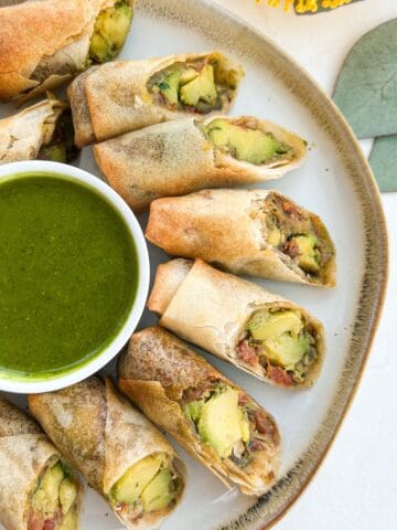 Overhead shot of avocado egg rolls served with a tamarind dipping sauce.