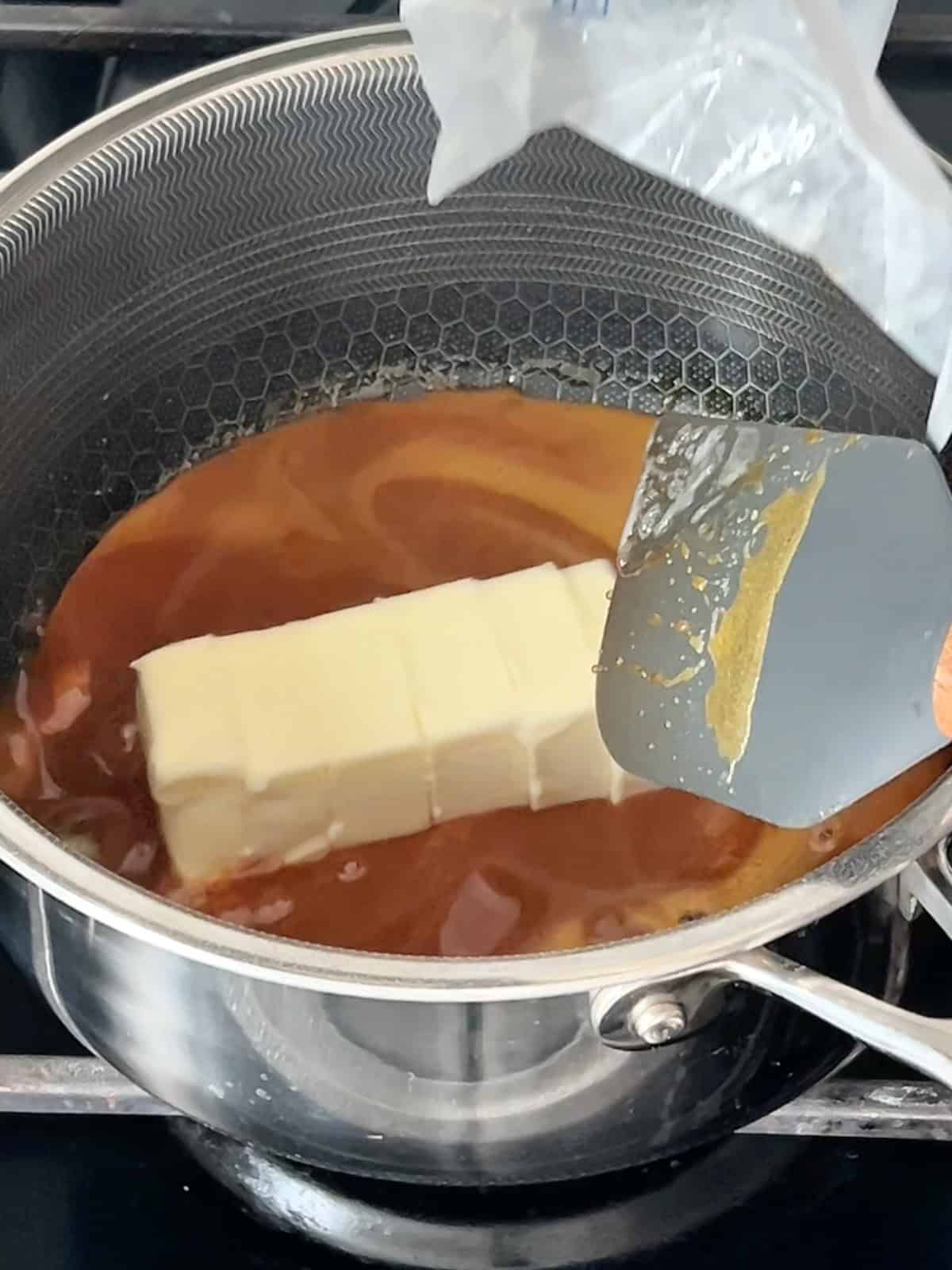 Adding butter to the caramel sauce.
