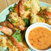Close up angled shot of coconut shrimp and bang bang sauce.