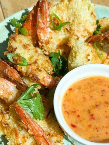 Close up angled shot of coconut shrimp and bang bang sauce.