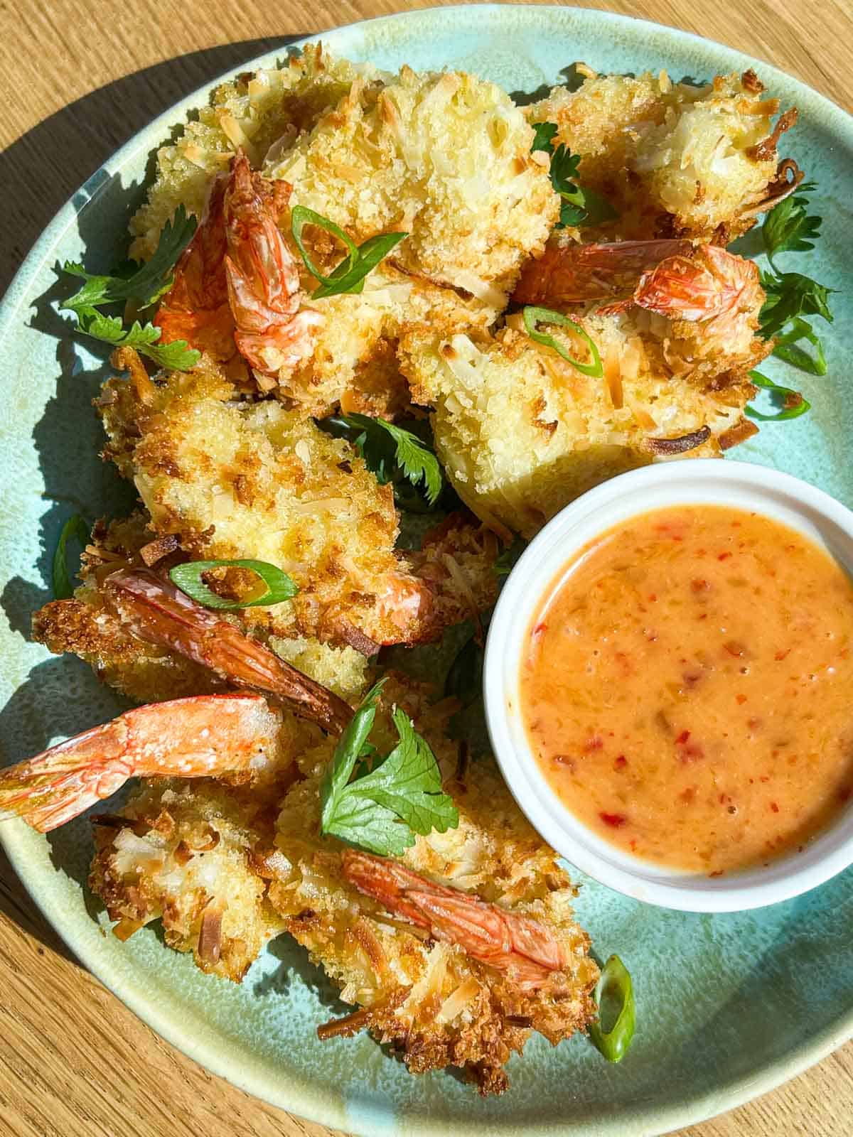 Overhead shot of finished coconut shrimp with bang bang sauce.