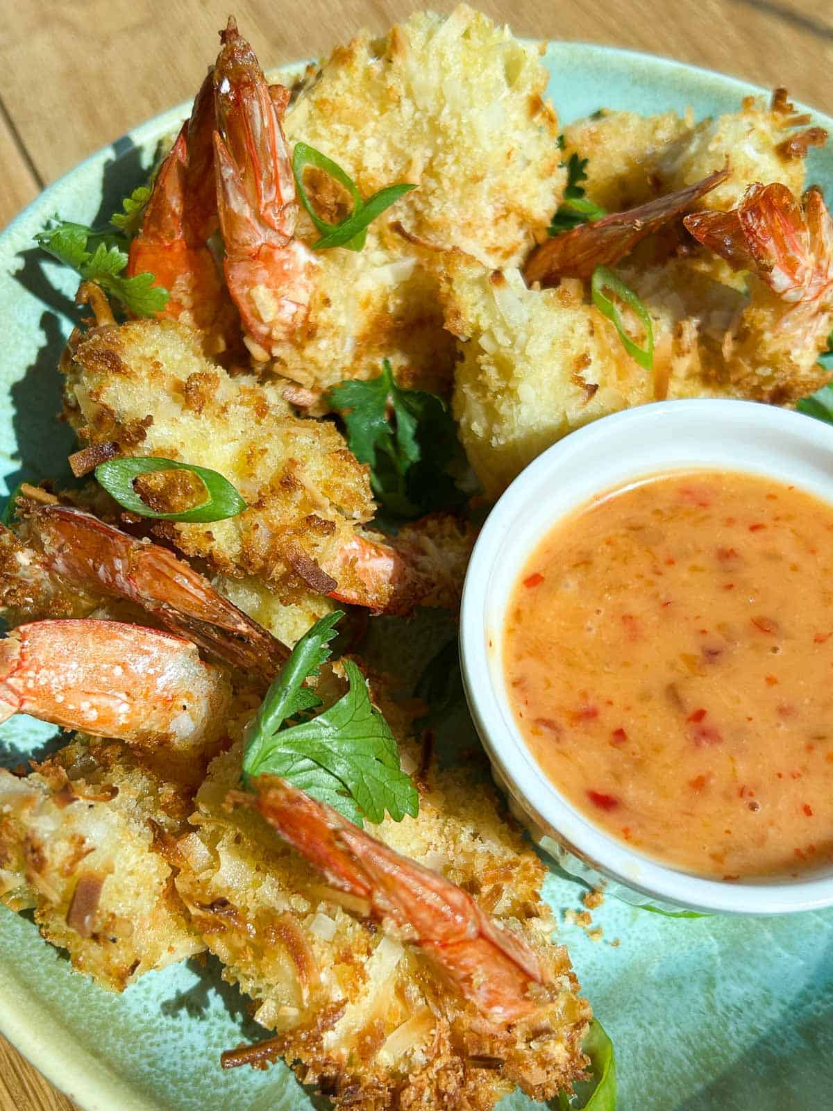Crispy coconut shrimp plated with bang bang sauce.