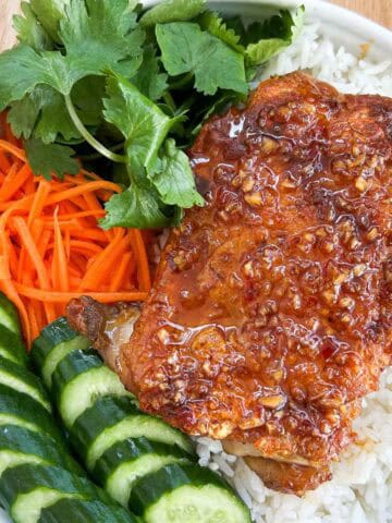 Close up shot of crispy fish sauce chicken with rice and vegetables.