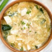 Miso egg drop soup in a bowl garnished with scallions and white pepper in a 1x1 photo.