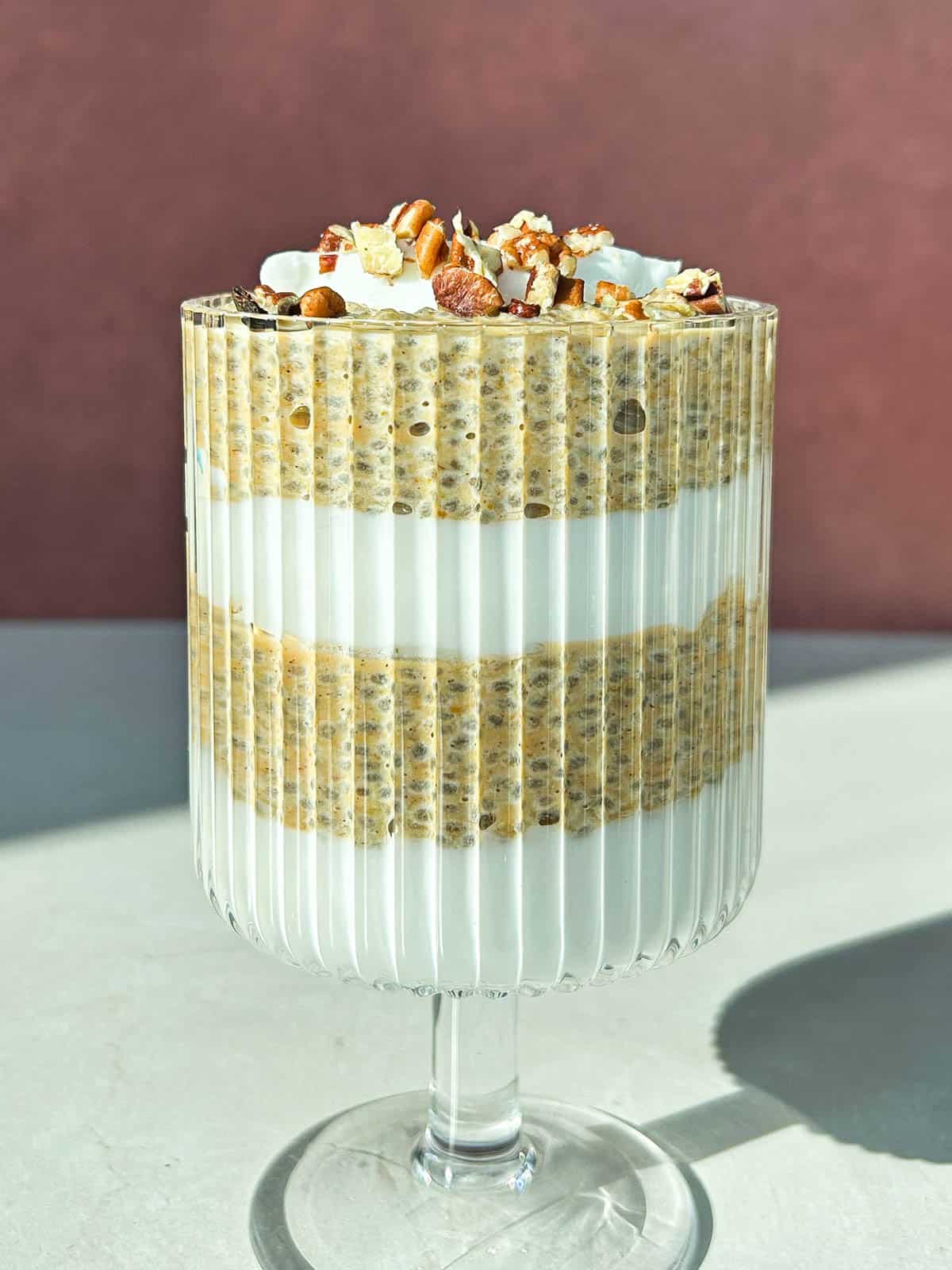 A zoomed out side angle of pumpkin chia pudding layered in between layers of greek yogurt.