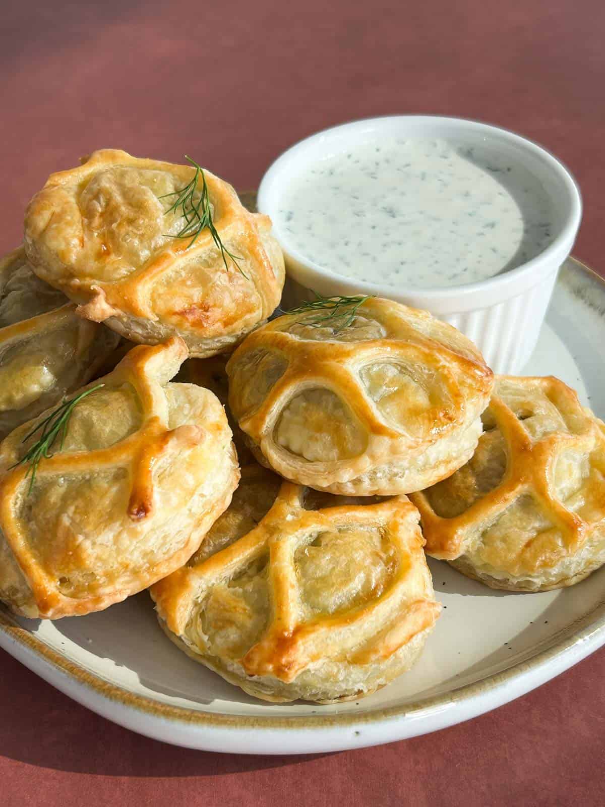 Plate of salmon wellington bites on a plate with the creamy dill dipping sauce.