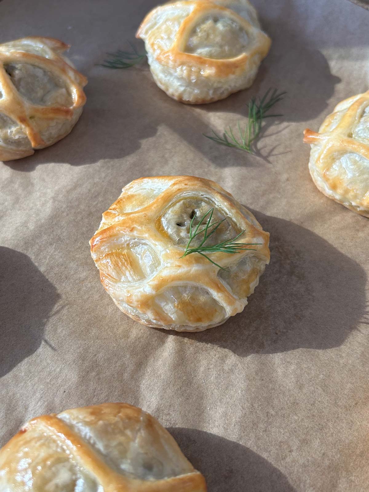 Cooked salmon wellington bites on parchment paper.