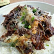 Melted gruyere cheese on pot roast over a bed of rice.