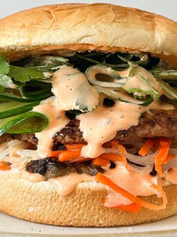 Close up shot of burger with sriracha mayo dripping down the burger.