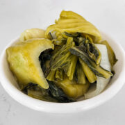 Close up shot of mustard greens in a small bowl.