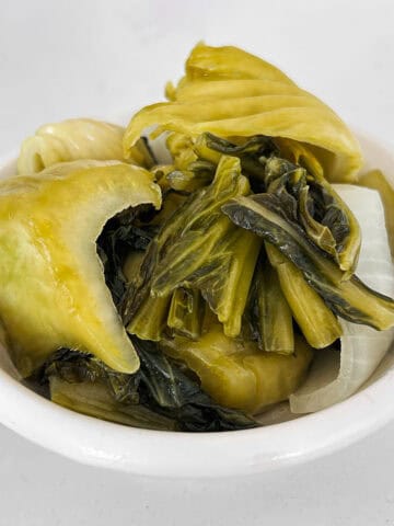 Close up shot of mustard greens in a small bowl.