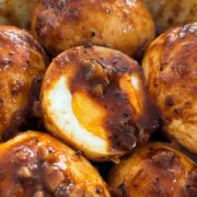 1x1 close up of hard boiled egg cut in half with Cajun butter sauce.