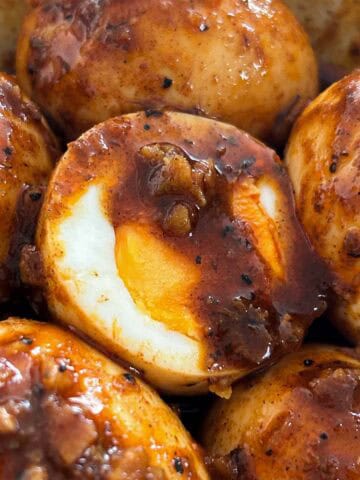 1x1 close up of hard boiled egg cut in half with Cajun butter sauce.