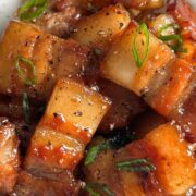 1x1 shot of caramelized pork belly with black pepper and scallions.