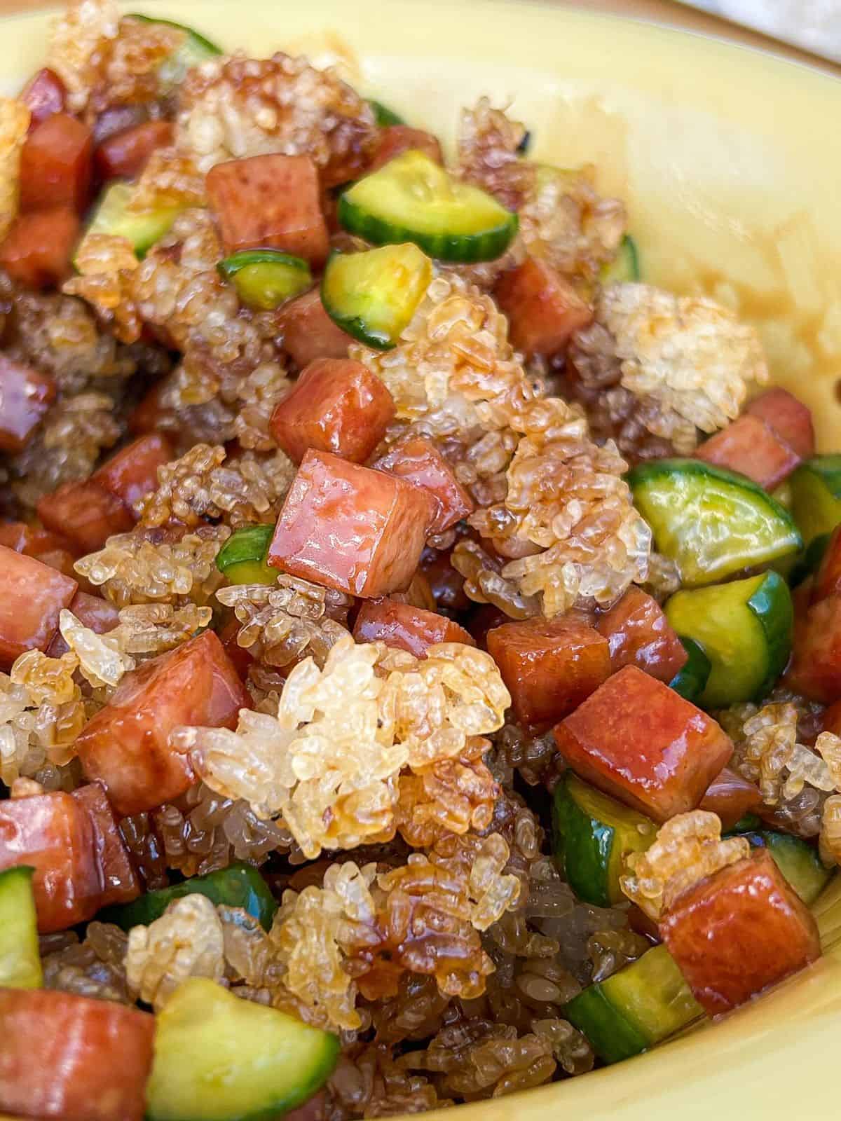 Spam musubi crispy rice salad with crispy golden rice, diced Spam, and chopped cucumber mixed together in a bowl.