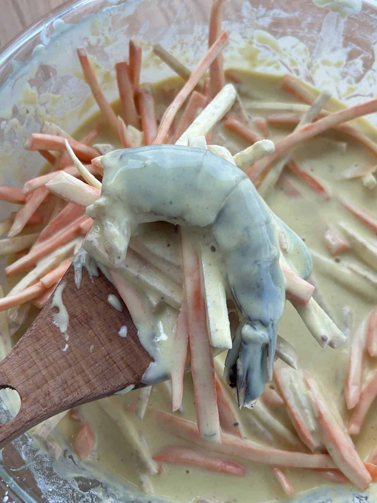 Shrimp and sweet potato on a wooden spatula.