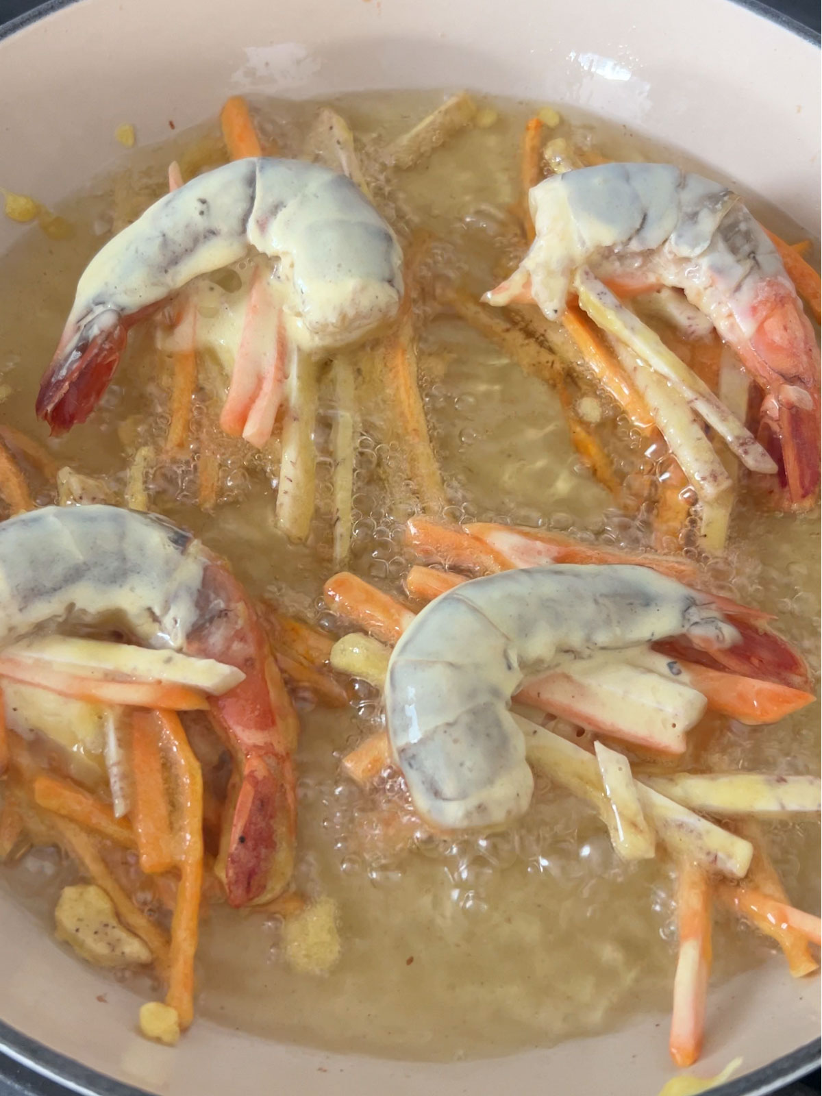 Shrimp fritters shallow frying in a pan.