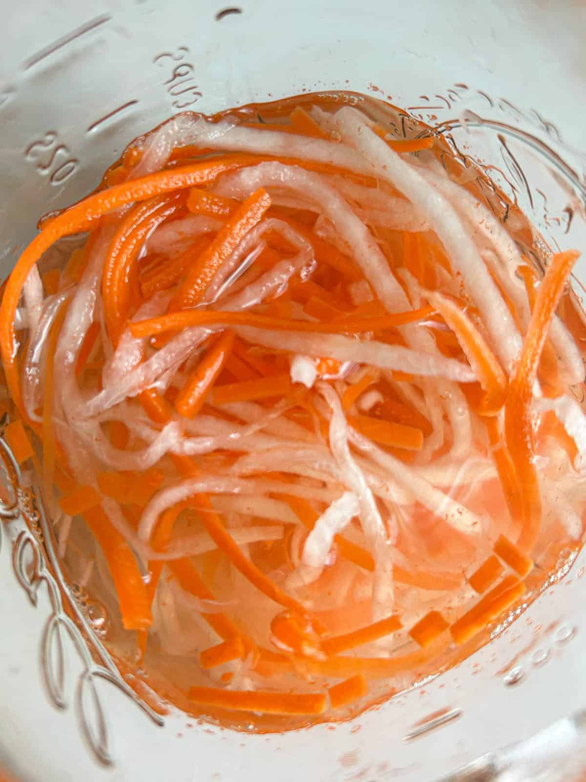 Overhead shot of Vietnamese pickled daikon radish and carrots in the brine.