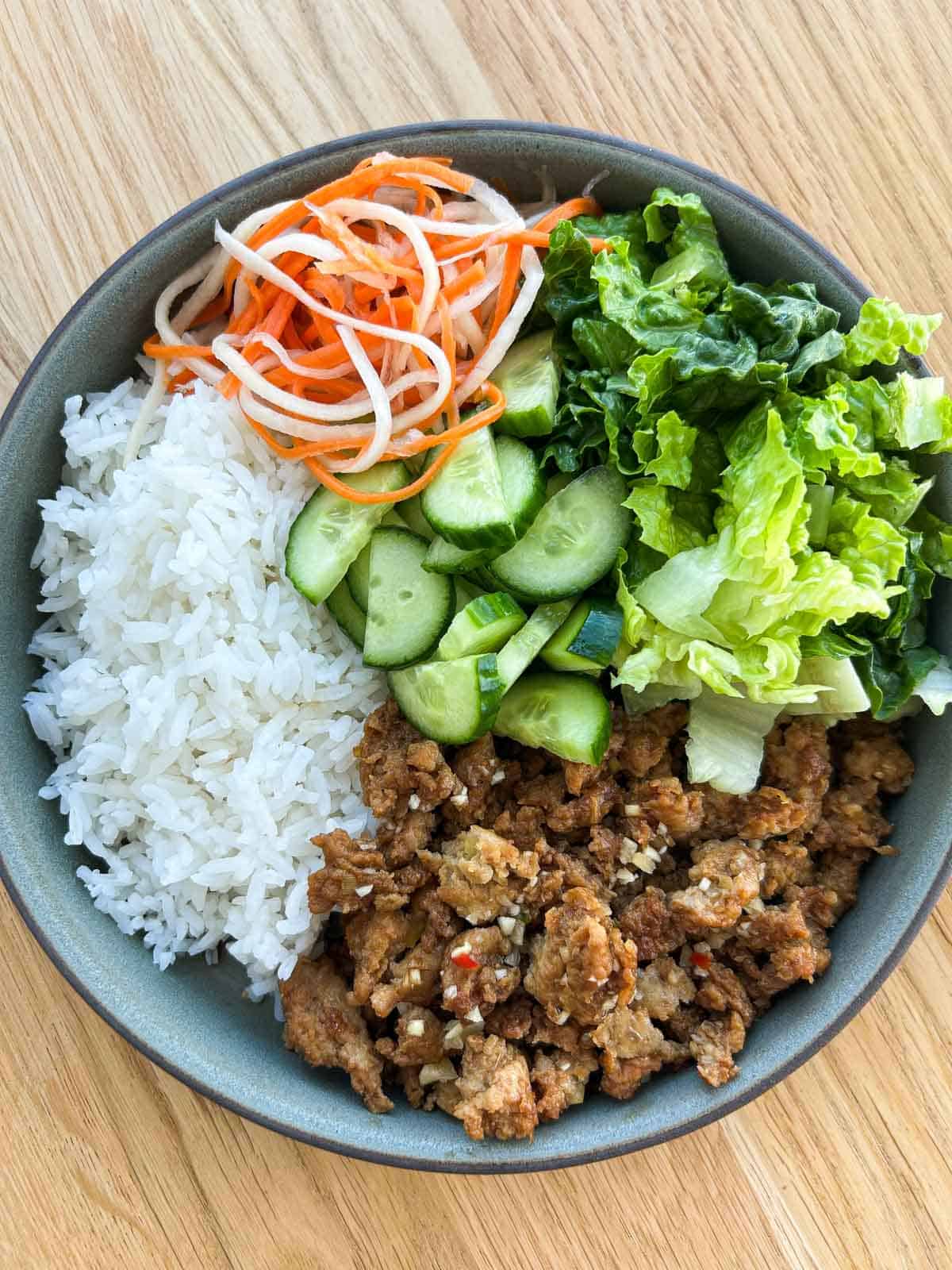 Lemongrass ground chicken plate with rice, veggies and Vietnamese pickles.
