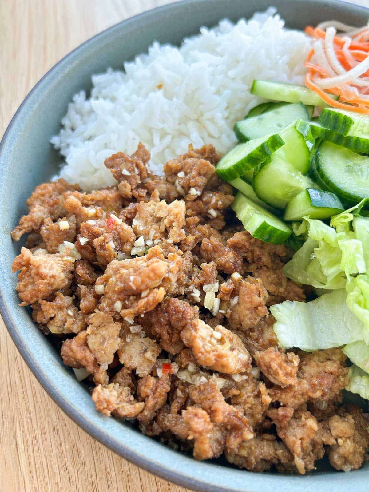 Close up shot of lemongrass ground chicken with rice and veggies.