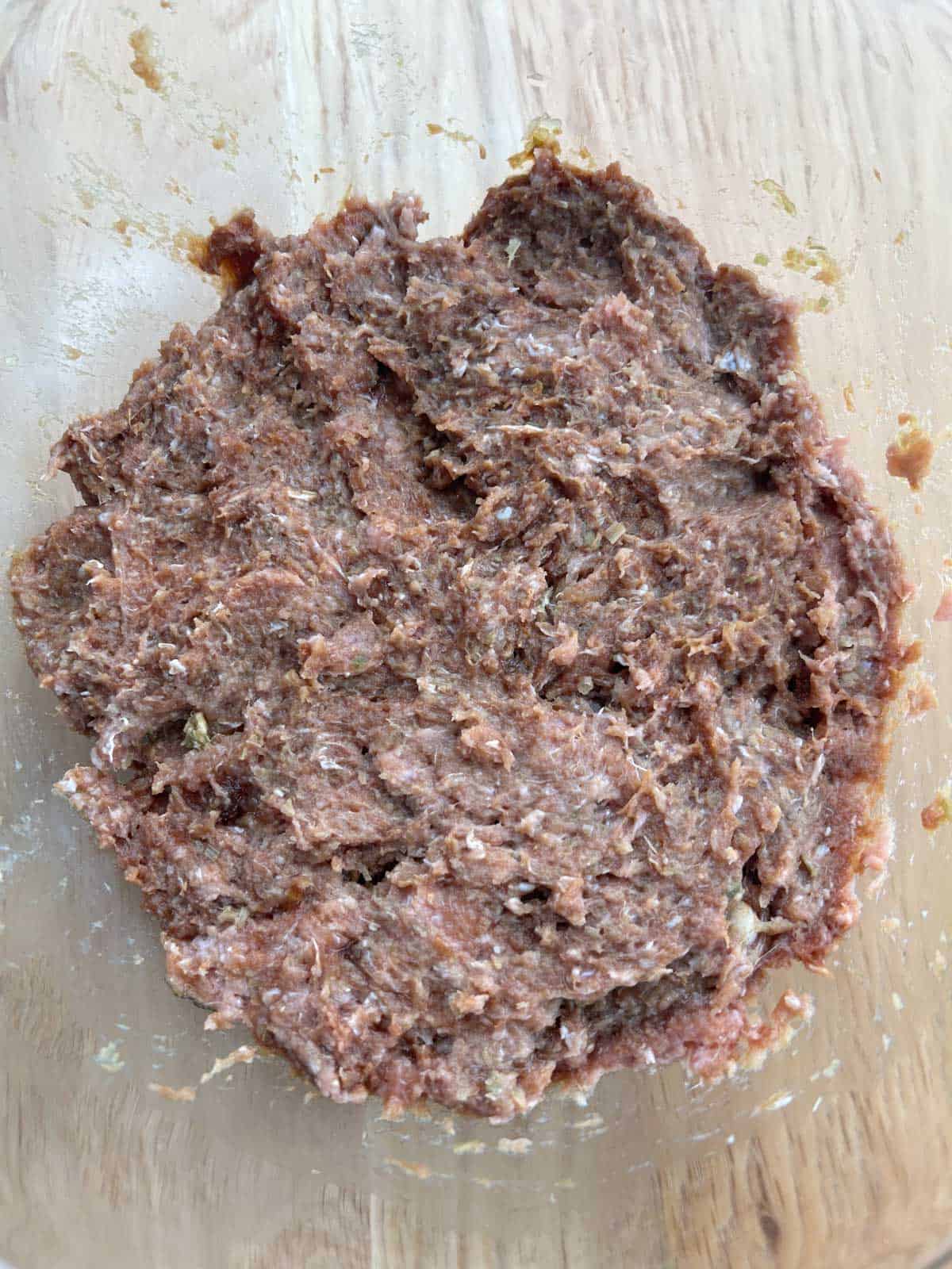 Ground chicken in a bowl with sauces.