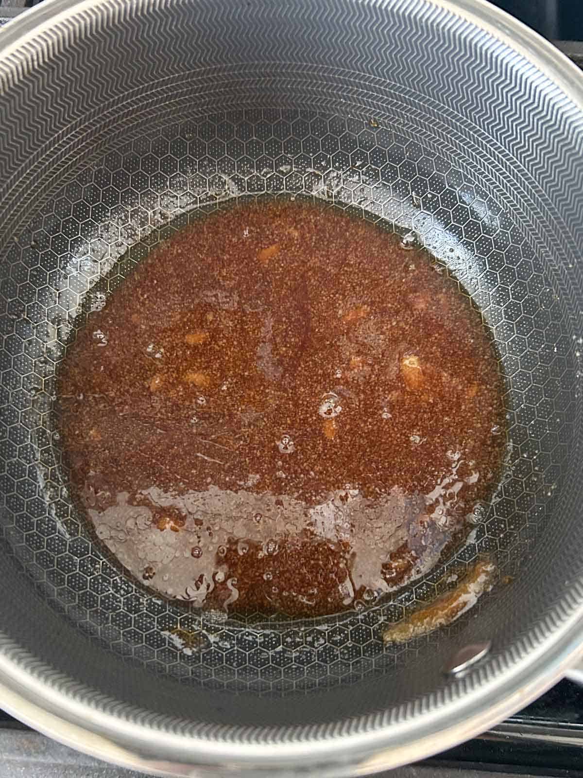 Sugar and oil melted into an amber caramel in a pot for Vietnamese fish sauce glaze.